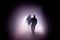 Silhouette of people in a dark misty underground creepy corridor