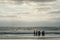 Silhouette of people enjoying and walking during peaceful moment of sunset at the beach