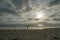 Silhouette of people enjoying and walking during peaceful moment of sunset at the beach