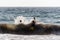 Silhouette of People playing, swimming in the waves in the island of Patmos, Greece in summer time