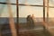 Silhouette of people, through a safety net, walking along the edge of a beach in the late afternoon