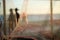Silhouette of people, through a safety net, walking along the edge of a beach in the late afternoon