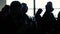 Silhouette of people sitting in airport hall with window and waiting departure