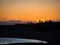 Silhouette of people watching dramatic sunset on Nautholsvik geothermal beach in Reykjavik