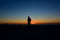 Silhouette of a person on the beach with a orange glowing sunset