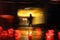 Silhouette of the person in movement. Wet asphalt. Red lights.