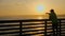 Silhouette of a person on an ocean fishing pier at the Gulf of Mexico on a hazy evening just before sunset