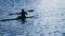 A silhouette of a person rowing a canoe