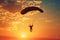 Silhouette of a person skydiving at sunset. Aerial adventure sports concept