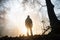 silhouette of a person standing in misty woods