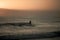 Silhouette of a person surfing on the background of the mesmerizing sunrise