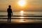 The silhouette photo of a man standing alone on the beach enjoy sunrise moment