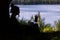 Silhouette photo of a Remote freelancer work in nature using renewable energy via a foldable solar panel. Young woman