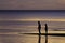 The silhouette photo of two brothers enjoy on the beach