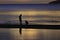 The silhouette photo of two brothers enjoy on the beach