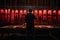 Silhouette of a photographer developing photos in a dark room. Man hanging printed photos in red lighted room. Old style