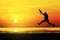 Silhouette of photographer jumping with sunset, seascape.