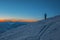 Silhouette of photographer standing on hill and making photo of evening valley