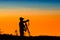 silhouette of photographer taking picture of landscape during sunset