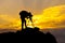 Silhouette of photographer or traveler taking a photograph sunset view landscape on top of stone with sunset sky.