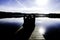 Silhouette picture of the couple sitting near the dark beautiful lake in South Island, New Zealand.