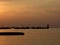 Silhouette of pier and walking people at dusk.