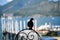 Silhouette of pigeon sitting on metal fence, lake and mountains in background