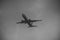 Silhouette of plane in grey sky. Passenger plane flies high in sky, flight. International flights, delivery