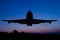 Silhouette of the plane on a sunset background.