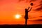 Silhouette of playing girl with ball  in the nature in cloudy sky