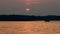 Silhouette of pontoon on minnesota lake at sunset