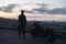 Silhouette portrait of biker or moto rider before sunrise standing near his bike