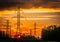 Silhouette of power grid against a dramatic sunset sky