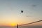 Silhouette of powered paraglider soaring flight over the sea against marvellous orange sunset sky. Paragliding - recreational and