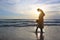 Silhouette Pregnant mother and daughter relaxing on the beach at sunset