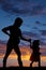 Silhouette of pregnant woman holding with a young child cowgirl