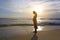 Silhouette pregnant woman standing alone on the beach at evening sunset