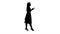 Silhouette Pretty blonde woman using cell phone texting message.