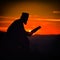 Silhouette of priest reading in the sunset light
