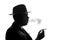 Silhouette of private detective lights cigarette. Agent looks like Al Capone stay side to camera. Police criminal scene in black