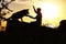 Silhouette profile of hapy man and dog sitting and playing on nature, boy training German Shepherd at sunset in a field, concept