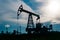 Silhouette of a pumpjack on an oil well against the background of sky