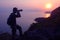 Silhouette purple of man climbing rock, Photographer on the mountain at sunrise