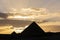 Silhouette of Pyramid of Menkaure and several people in front of sunset in Giza