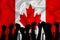 Silhouette of raised arms and clenched fists on the background of the flag of  canada. The concept of power, power, conflict. With