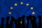 Silhouette of raised arms and clenched fists on the background of the flag of European Union. The concept of power, power,