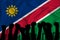 Silhouette of raised arms and clenched fists on the background of the flag of Namibia. The concept of power,  conflict. With place