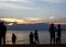 Silhouette rear view of people standing at the beach sunset together