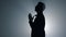 Silhouette religious man whispering prayer indoors. Believer praying in dark.