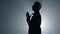 Silhouette religious man whispering prayer indoors. Believer praying in dark.